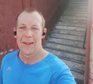 Image of Richard in his running kit and earphones whilst out in Afghanistan